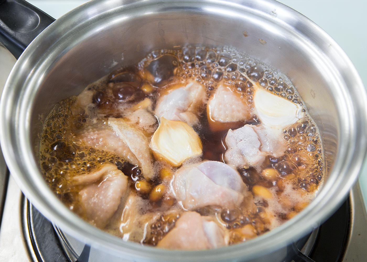 鍋に鶏肉、大豆、にんにくを皮付きのまま入れ、【Ａ】を加えて火にかける。