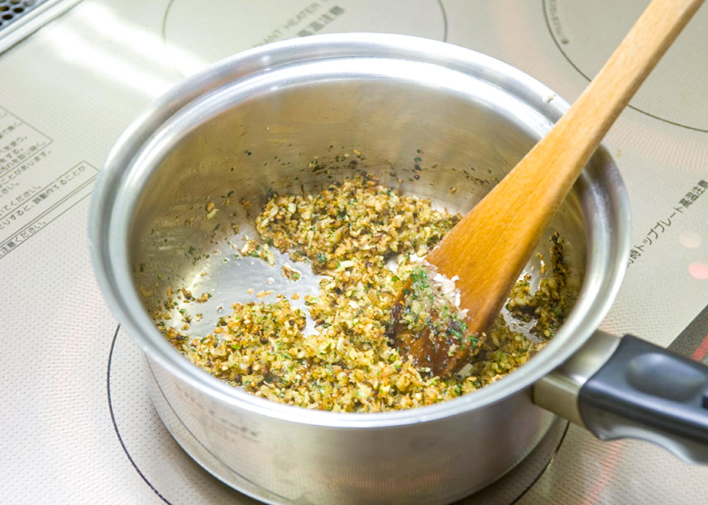 鍋ににんにくとオリーブ油を入れ、弱火で炒める。にんにくが色付いてきたら玉ねぎを加え、しんなりするまで炒め、パセリとパン粉を加えて炒める