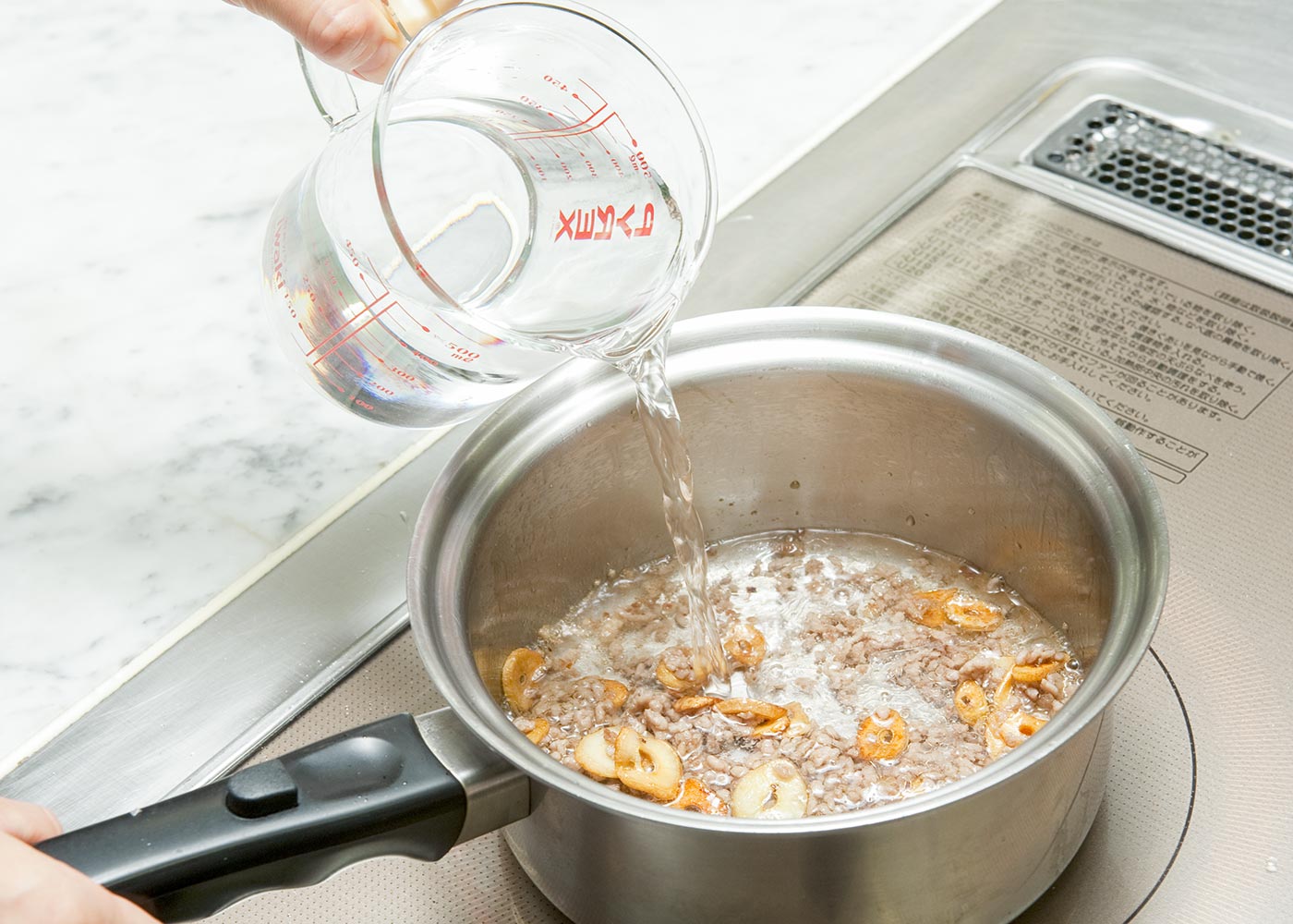 鍋に水を注ぎ、ラーメンの添付のスープを加えて、ラーメンを加える。